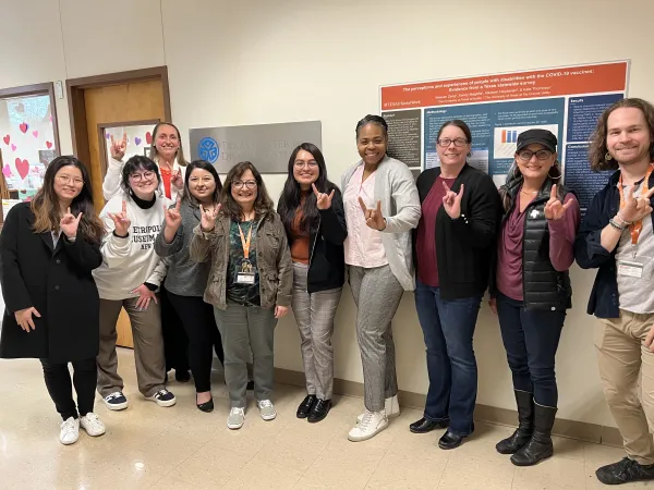 texas addm team and cdc leaders posing for a picture with texas hook em sign