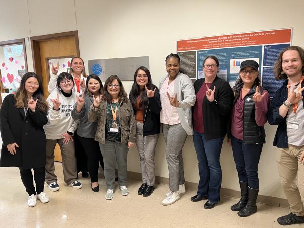 texas addm team and cdc leaders posing for a picture with texas hook em sign
