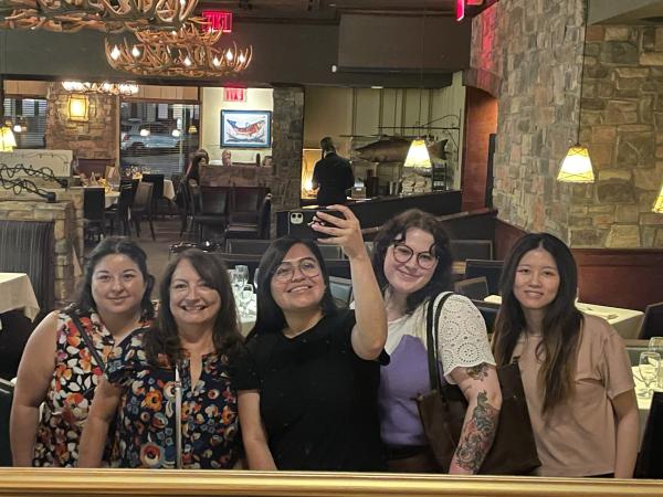 From left to right image of Sandra Vanegas, Sandy Magana, Hilda Torres, Adra Mersinger, and Minyu Zhang standing in front of a mirror.