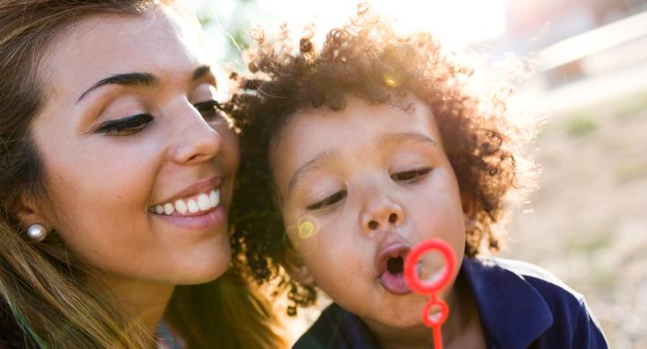 image shows a brown skin female with long brown hair next to curly hair brown skin toddler